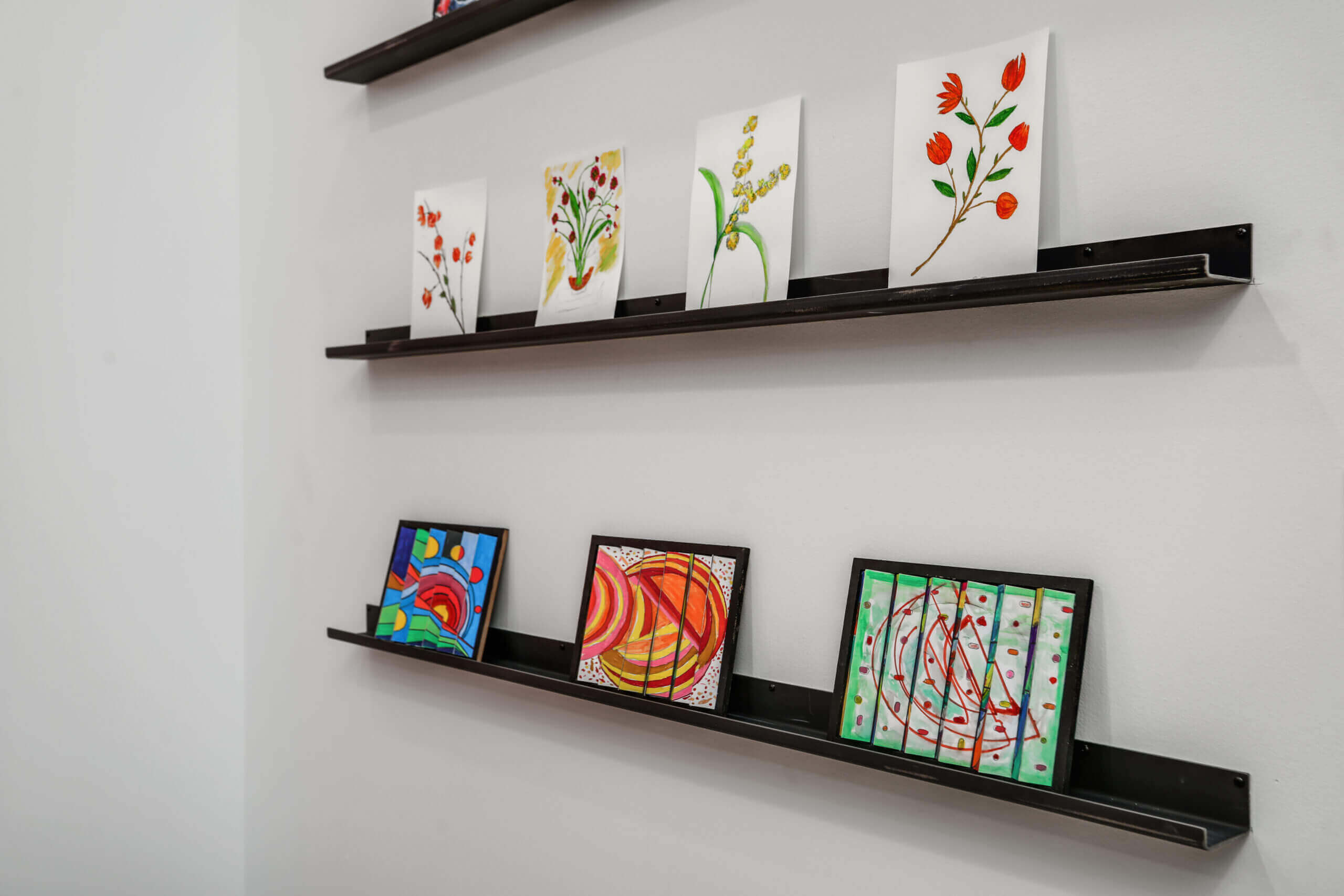 Paintings done by senior residents along a wall