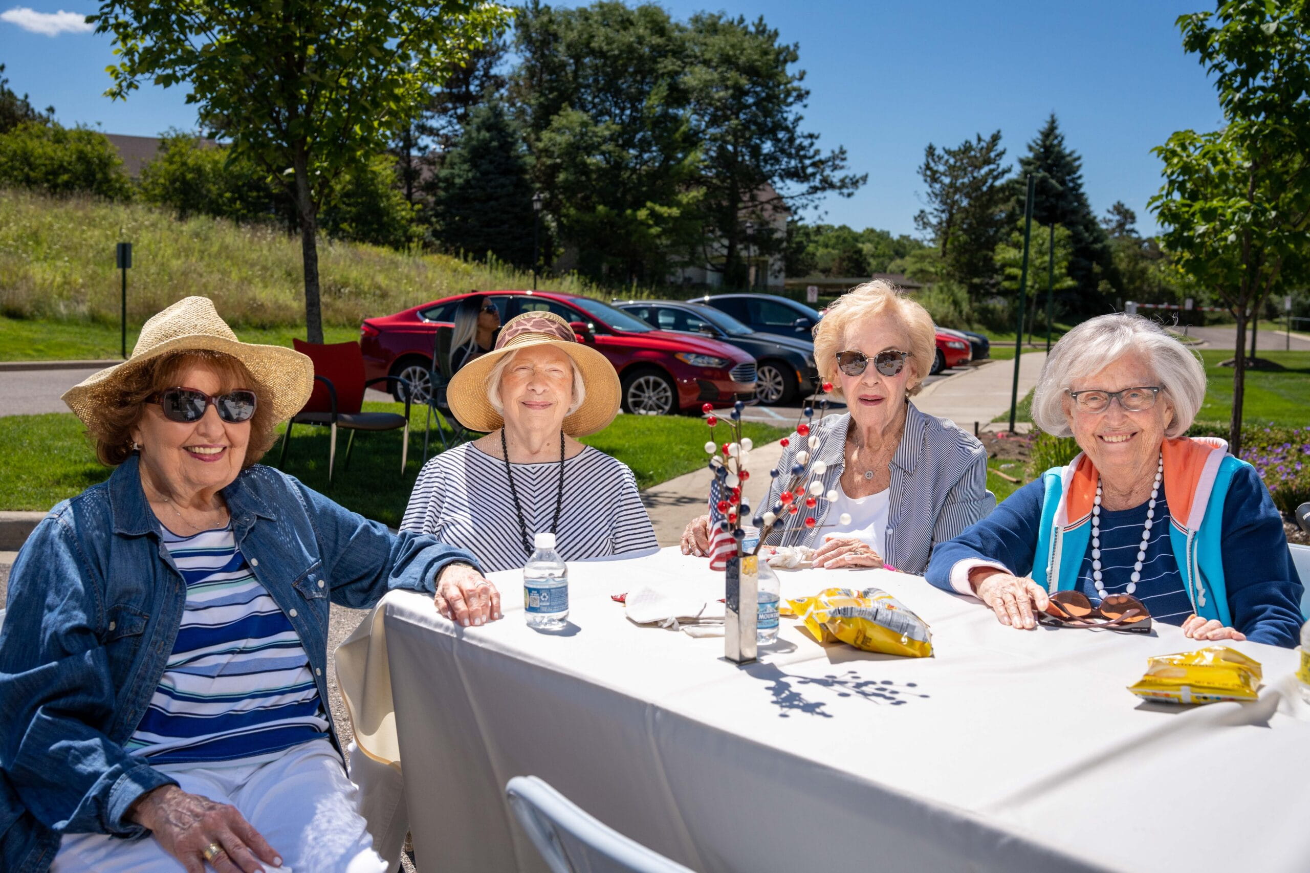 Senior women happily sitting outside around a table at All Seasons