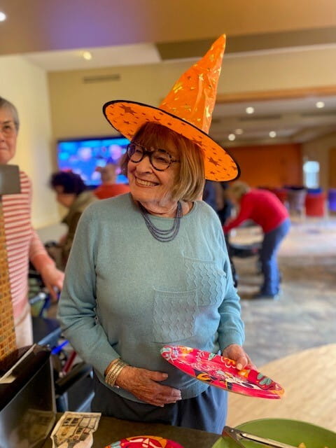 Smiling senior woman wearing an orange hat at All Seasons