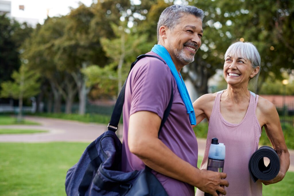 Seniors smile as they stay active with outdoor exercise. All Seasons Birmingham offers a number of activities for active seniors. Pictured: a senior couple enjoying time together outside.